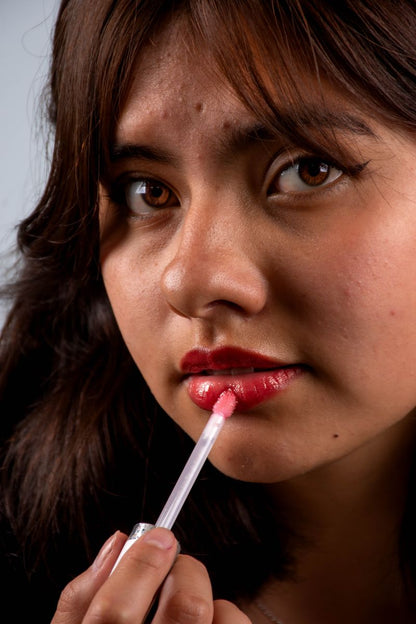 Mujer aplicando brillo labial primer plano