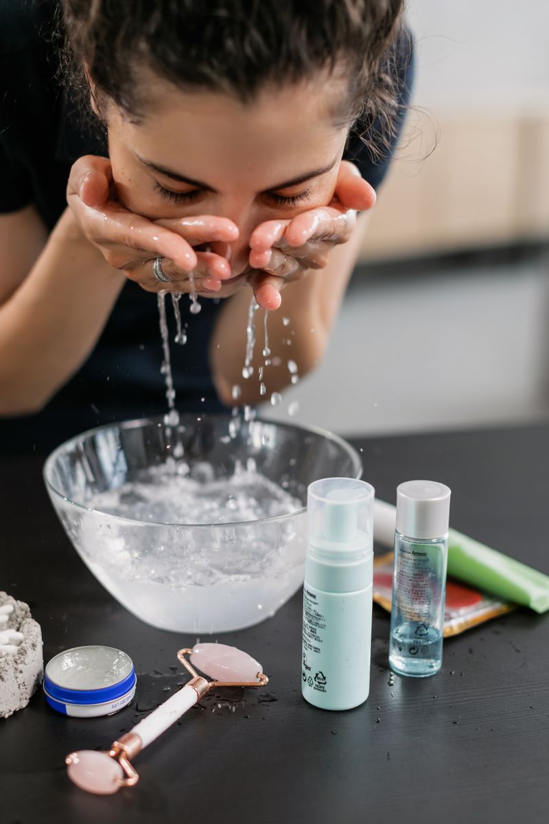 Mujer limpiando rostro agua micelar